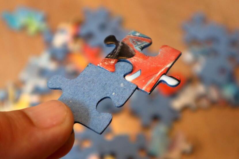 Close-up van twee niet passende puzzelstukjes die aan elkaar zijn geforceerd.