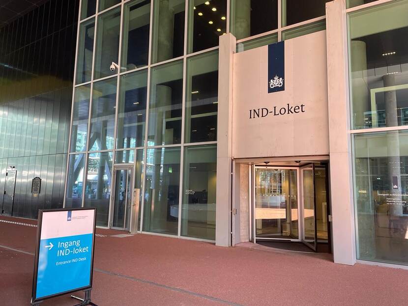 Ingang IND gebouw in Den Haag met voor de deur een bord waarop staat 'Ingang IND-loket'.
