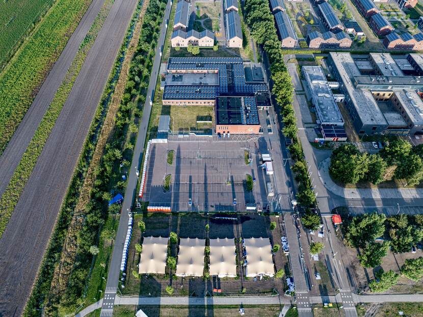 Luchtfoto van COA-locatie in Ter Apel. Van onder naar boven: tenten, de parkeerplaats, de sporthal en daarachter de verblijven in het AZC.